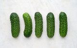 Fototapeta  - Set of ripe cucumbers on white marble background, top view