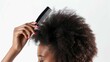 Combing afro hair with comb on white background