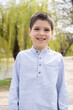 © Zarina Lukash - Laughing six-year-old boy in shirt walking in spring park.
