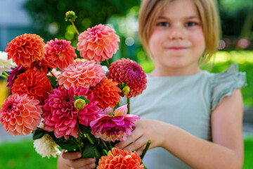 Wall Mural - Close up of little preschool girl with dahlia flower bouquet. Close-up of happy child holding colorful garden summer flowers for mothers day or birthday. Closeup of flowers in rainbow colors.