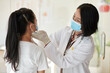 Pediatrician palpating neck lymph nodes of teenage girl