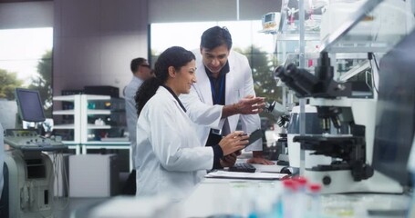 Indian Male Medical Supervisor Having a Conversation with a Hispanic Female Scientist About a Gene Editing Research Project, Technology and Experiments. Smart Diverse Team Working in a Laboratory