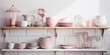White kitchen. Shelves with pink crockery and kitchen utensils.