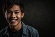young indonesian teenage boy on plain bright black background laughing hysterically looking at camera background banner template ad marketing concept from Generative AI