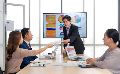 High-powered business professional discussing strategic plan and making decision at a conference table in a professional office setting.