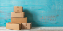 Stack Of Cardboard Boxes On A Light Wooden Tabletop On Blue Wall Background, Copy Space , Small Business Concept