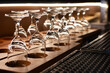 Row of the upturned crystal wine glasses on bar table