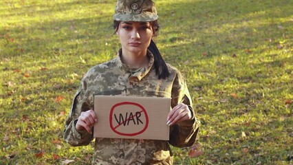 Wall Mural - Female soldier hold patriotic nameplate. Stop War. Support and solidarity. Dressed in the camouflage military uniform. Independence. Armed Forces of Ukraine. Woman serving in ukrainian army 