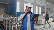 Busy engaged working occupied African-American male talking on phone having conversation dialogue. Tall businesslike man wearing nice hardhat look in his nice tablet technology gadget.