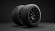 Two black tires are shown on a dark background