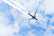 Passenger airplane flying far away in the clouds sky
