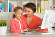 Close up porait of mother and daughter using laptop