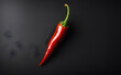 A single red chili pepper on a black background, symbolizing spice and intensity