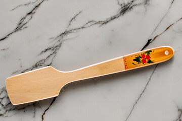 Canvas Print - One wooden spatula on a marble table, macro, top view.