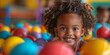 A cheerful portrait of a playful black baby boy enjoying colorful playtime at the entertainment center.