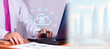 © Andrey - businessman in his office in front of his laptop. cloud server hologram with many business icons.