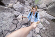 Close up on unrecognizable man pulling caucasian woman hiker hand up to the top of the c;iff