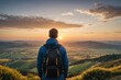 Man with backpack looking at view at sunset