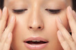 Fingers on face of young beautiful woman close-up