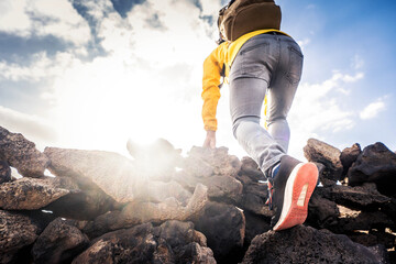 Wall Mural - Hiker climbing mountains - Close up of successful climber standing on the top the of cliff - Focus on shoes