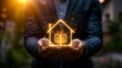 © Palung - Businessman holding a virtual house and financial icon with a growth graph, representing a real estate business concept on a dark background.