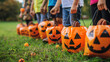 Closeup of children with hands holding pumpkins bags playing trick or treat outdoors.