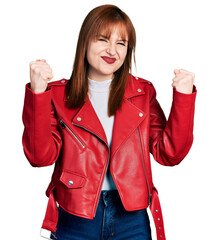 Sticker - Redhead young woman wearing red leather jacket screaming proud, celebrating victory and success very excited with raised arms