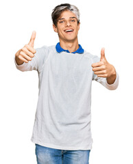 Canvas Print - Young hispanic man wearing casual clothes approving doing positive gesture with hand, thumbs up smiling and happy for success. winner gesture.