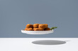 © ADDICTIVE STOCK - Floating plate with croquettes on gray backdrop