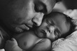 Tender Moments: New Father Embracing Sleeping Newborn in Black and White