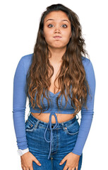 Poster - Young hispanic girl wearing casual clothes puffing cheeks with funny face. mouth inflated with air, crazy expression.