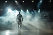 Silhouette of a basketball player after the game, walking against the background of smoke and sports spotlights on the basketball court.