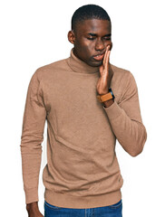 Wall Mural - Young african american man wearing casual winter sweater touching mouth with hand with painful expression because of toothache or dental illness on teeth. dentist