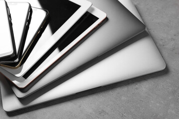 Many different modern gadgets on grey table, closeup