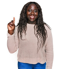 Canvas Print - Young african woman wearing wool winter sweater showing and pointing up with finger number one while smiling confident and happy.