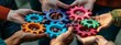 A group of hands holding colored gears, symbolizing collaboration teamwork and growth in business or social connections