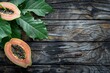 Ripe papaya with leaf on wooden surface