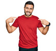 © Krakenimages.com - Young hispanic man wearing casual clothes looking confident with smile on face, pointing oneself with fingers proud and happy.