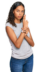 Poster - Young african american girl wearing casual clothes holding symbolic gun with hand gesture, playing killing shooting weapons, angry face