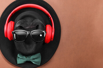 Poster - Man's face made of artificial mustache, sunglasses and hat on brown background, top view. Space for text