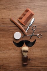 Poster - Artificial moustache and barber tools on wooden table, flat lay