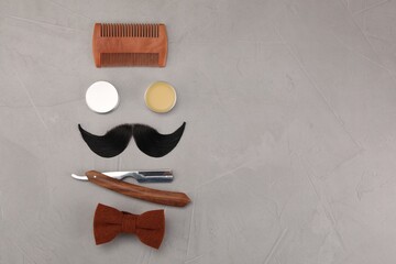 Poster - Artificial moustache and barber tools on grey table, flat lay. Space for text