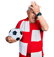 Canvas Print - Senior man with grey hair football hooligan holding ball surprised with hand on head for mistake, remember error. forgot, bad memory concept.