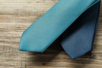 Two neckties on wooden table, top view