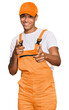 © Krakenimages.com - Young handsome african american man wearing handyman uniform pointing fingers to camera with happy and funny face. good energy and vibes.