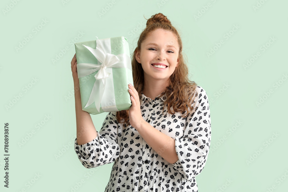 Happy beautiful woman with Birthday gift on light background