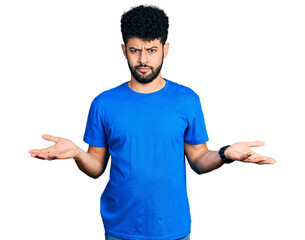 Canvas Print - Young arab man with beard wearing casual blue t shirt clueless and confused with open arms, no idea concept.