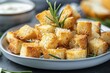 Closeup of plate with tasty crispy croutons and rosemary seasoned sauce