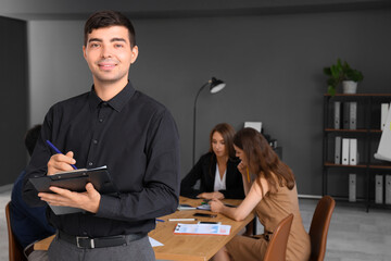 Wall Mural - Young businessman with clipboard working in office