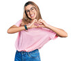 © Krakenimages.com - Hispanic young woman wearing casual t shirt and glasses smiling in love showing heart symbol and shape with hands. romantic concept.